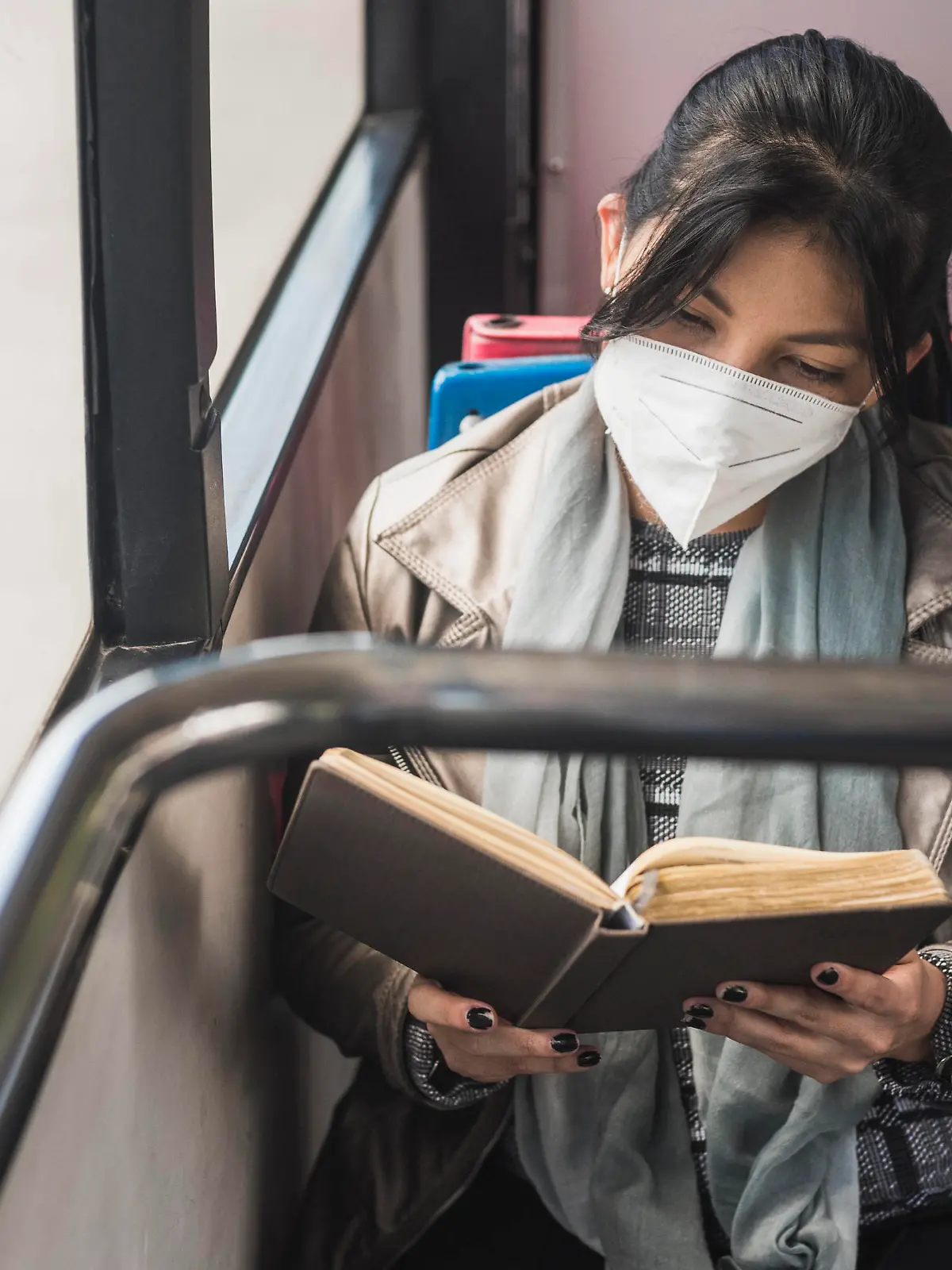  Woman wearing protective mask while reading book in bus model released Symbolfoto DSIF00076