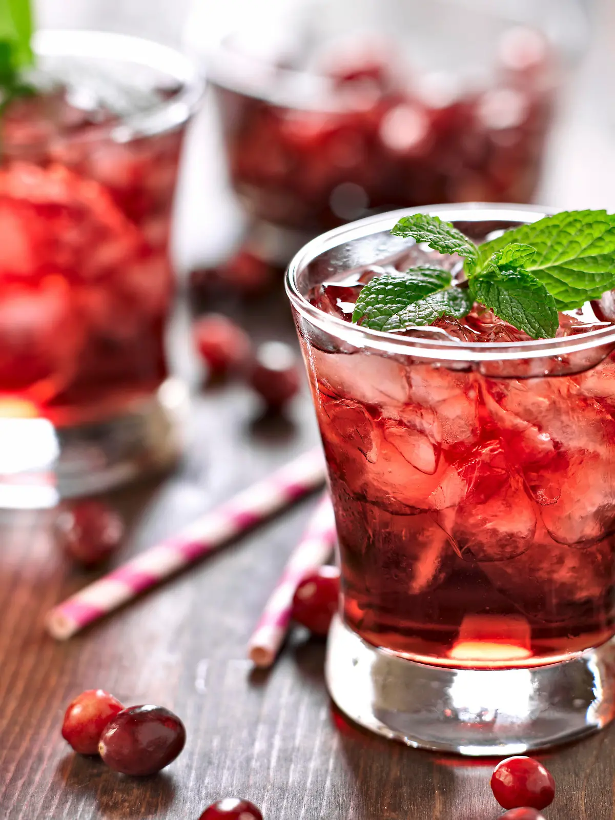 close up photo of a cranberry cocktail with mint garnish.