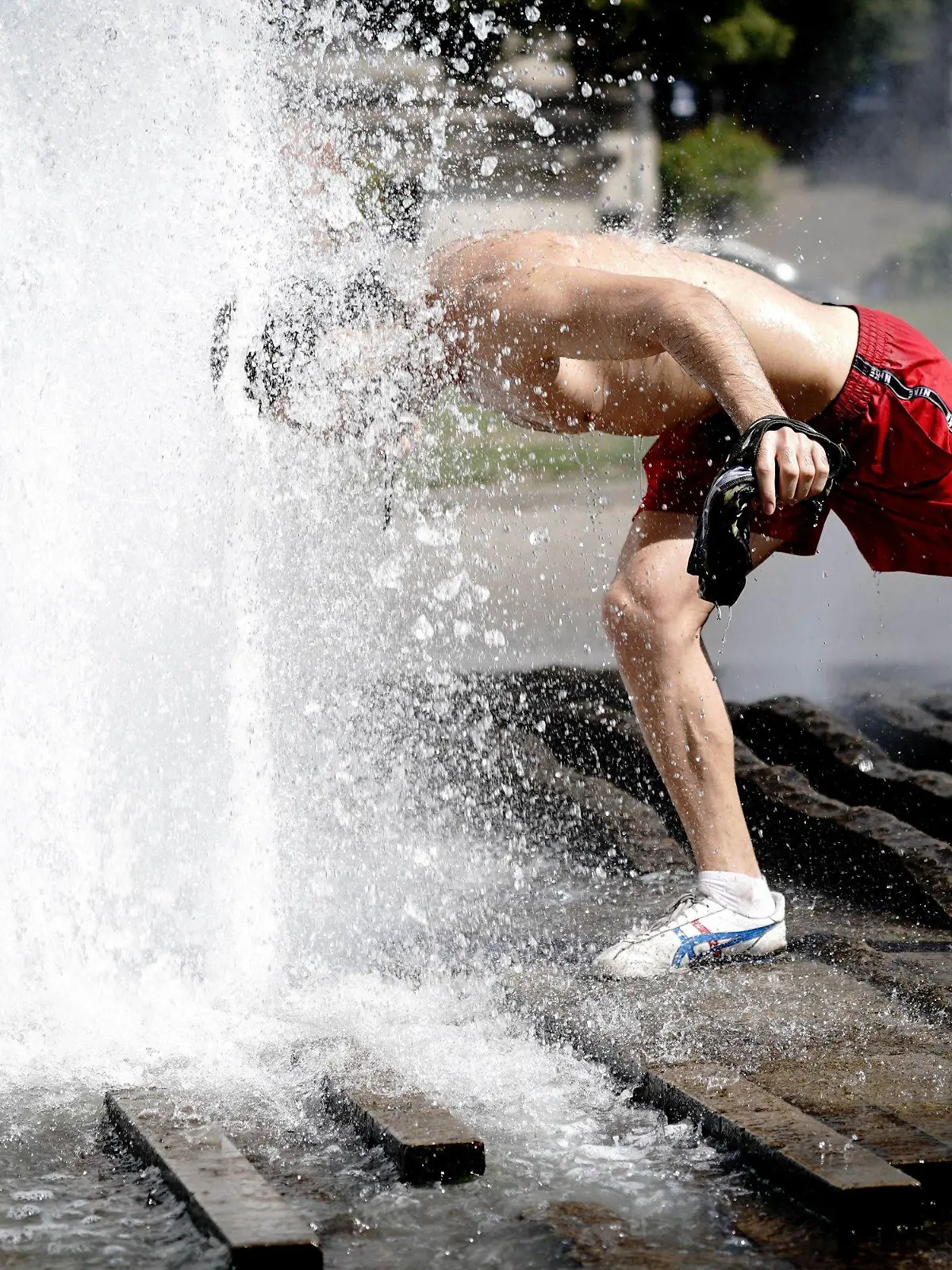 21.08.2020, Berlin: Ein Passant erfrischt sich im Brunnen im Lustgarten bei hohen Temperaturen. Foto: Kay Nietfeld/dpa +++ dpa-Bildfunk +++