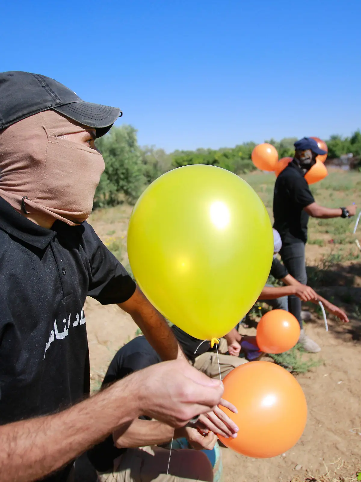  June 15, 2021, Gaza, Palestine: Masked Palestinians launch incendiary balloons from the Gaza Strip towards Israel..Palestinian activists launch incendiary balloons from the Gaza Strip towards Israel in protest to the flag march in East Jerusalem happening now and concerns of a fresh outbreak of violence as some 5,000 right-wing nationalists are due to parade through Jerusalem s Old City waving Israel s blue and white flag. Gaza incendiary balloons burned farmland in at least 13 different locations reports.Israeli media. Gaza Palestine - ZUMAs197 20210615_zaa_s197_111 Copyright: xAhmedxZakotx