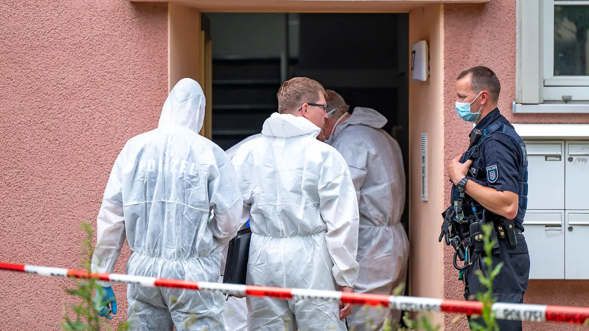 15.06.2021, Sachsen, Weimar: Kriminalbeamte stehen vor einem Haus, das mit rot-weißem Flatterband abgesperrt ist. In dem Gebäude wurde eine männliche Leiche gefunden. Die Ermittler gehen von einem Tötungsdelikt aus. Foto: Johannes Krey/dpa-Zentralbild/dpa +++ dpa-Bildfunk +++