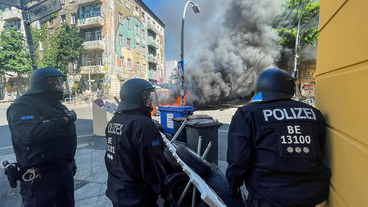 Police officers stand near burning barricades at Rigaer Street in Berlin, Germany, June 16, 2021. REUTERS/Hannibal Hanschke REFILE- CORRECTING YEAR