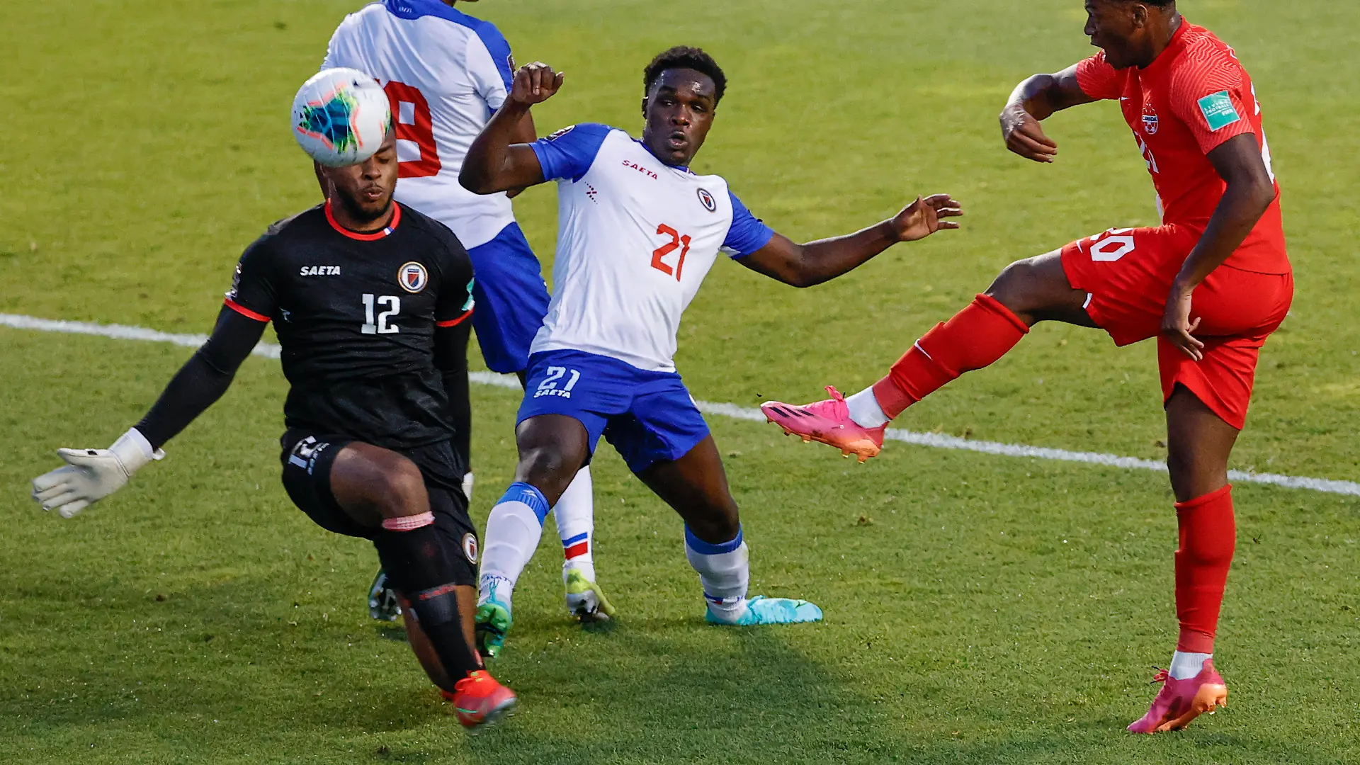 Canada's Jonathan David (20) tries to score against Haiti's Josue Duverger (12) and Bryan Alceus (21) during the first half of a World Cup qualifying soccer match Tuesday, June 15, 2021, in Bridgeview, Ill. (AP Photo/Kamil Krzaczynski)