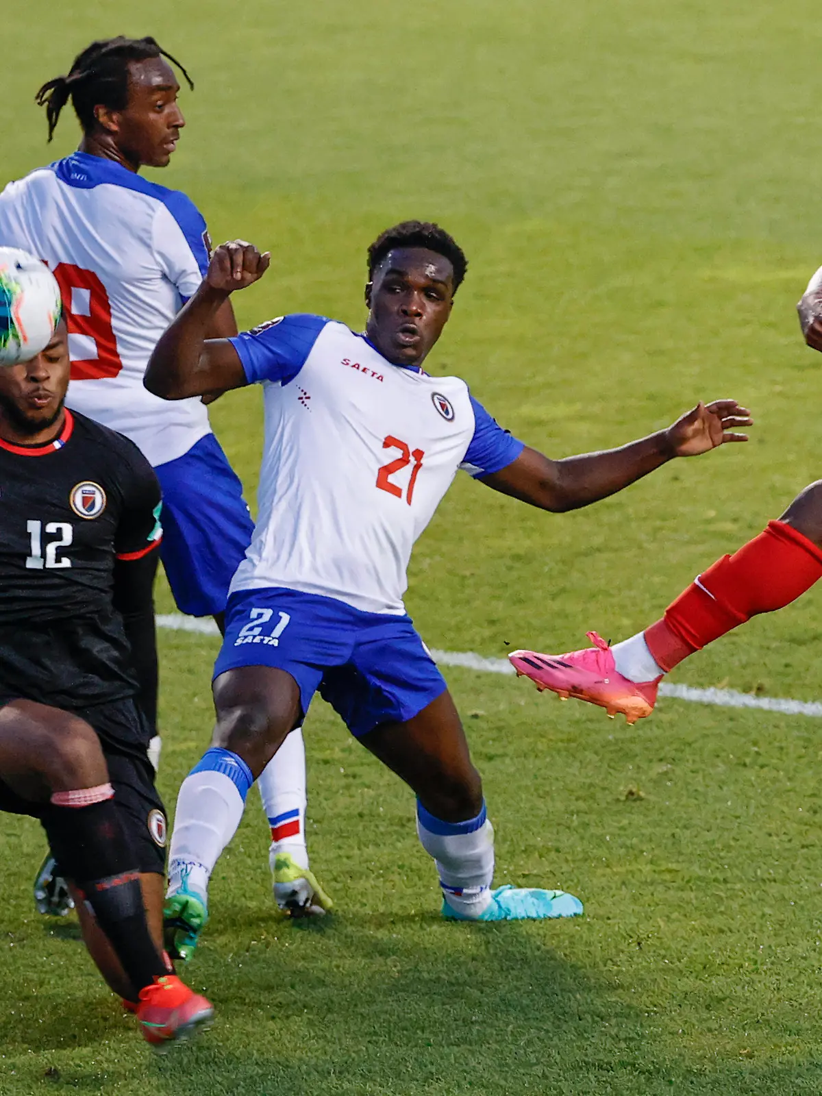Canada's Jonathan David (20) tries to score against Haiti's Josue Duverger (12) and Bryan Alceus (21) during the first half of a World Cup qualifying soccer match Tuesday, June 15, 2021, in Bridgeview, Ill. (AP Photo/Kamil Krzaczynski)