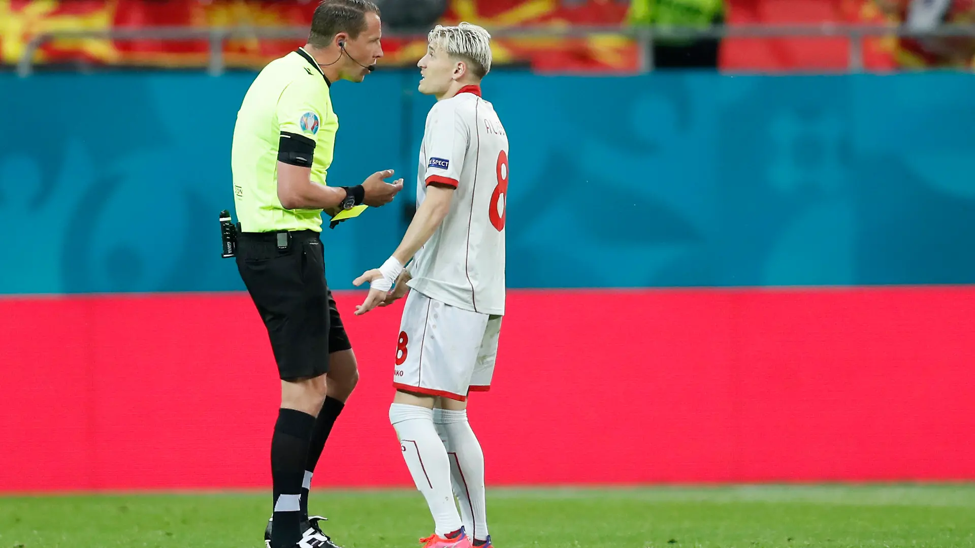 Referee Andreas Ekberg, left, discusses with North Macedonia's Ezgjan Alioski during the Euro 2020 soccer championship group C match between Austria and Northern Macedonia at the National Arena stadium in Bucharest, Romania, Sunday, June 13, 2021. (Robert Ghement/Pool via AP)