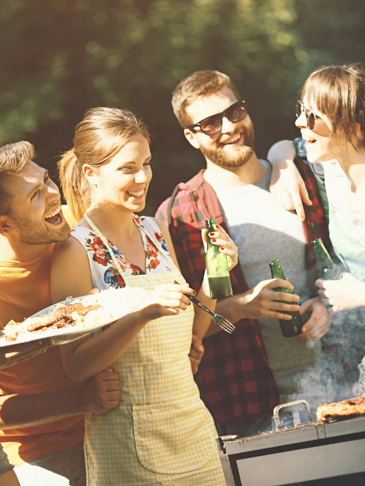 Freunde feiern eine Grillparty im Garten.