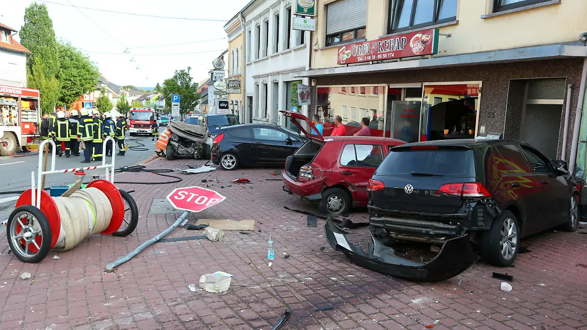 ARCHIV - 23.08.2017, Saarland, Saarwellingen: Ein Bild der Verwüstung bietet sich, nachdem ein Autofahrer ungebremst gegen einen Wagen (links hinten neben der Gruppe von Feuerwehrleuten) raste, in dem eine Frau und ein zwölfjähriges Kind dabei tödlich verletzt wurden. (zu dpa «Zu schnell und am Handy: Mordprozess wegen rücksichtloser Fahrweise») Foto: picture alliance / Simon Mario Avenia/dpa +++ dpa-Bildfunk +++
