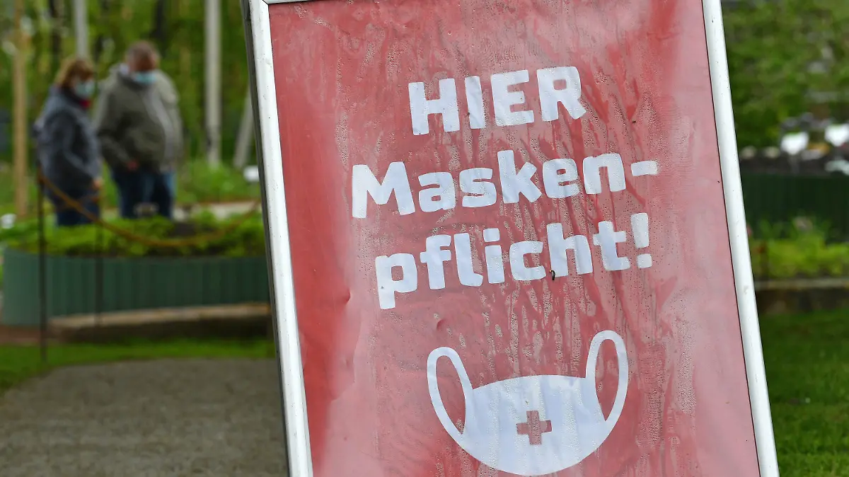 20.05.2021, Thüringen, Erfurt: «Hier Maskenpflicht» steht auf dem Schild in einem kleinen Bereich auf dem Gelände der Bundesgartenschau im egapark. Nachdem rund einen Monat eine Testpflicht für einen Besuch der Bundesgartenschau (Buga) galt, entfällt diese ab dem 21. Mai. Für die derzeit geöffneten Freiflächen ist dann kein amtlicher negativer Corona-Test oder Impfnachweis mehr notwendig. Das ist aufgrund der anhaltenden Sieben-Tage-Inzidenz von unter 100 in der thüringischen Landeshauptstadt möglich. Foto: Martin Schutt/dpa-Zentralbild/dpa +++ dpa-Bildfunk +++