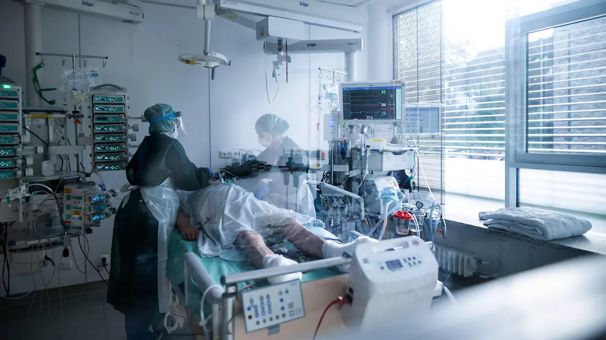 ARCHIV - 28.10.2020, Nordrhein-Westfalen, Essen: Mitarbeiterinnen der Pflege in Schutzausrüstung betreut einen Corona-Patienten. Karl-Josef Laumann (CDU), Minister für Arbeit, Gesundheit und Soziales des Landes Nordrhein-Westfalen, informiert am Mittwoch über die aktuelle Lage und Maßnahmen der NRW-Landesregierung im Rahmen der Corona-Pandemie. Foto: Fabian Strauch/dpa - ACHTUNG: Teile des Bildes wurden aus rechtlichen Gründen gepixelt +++ dpa-Bildfunk +++