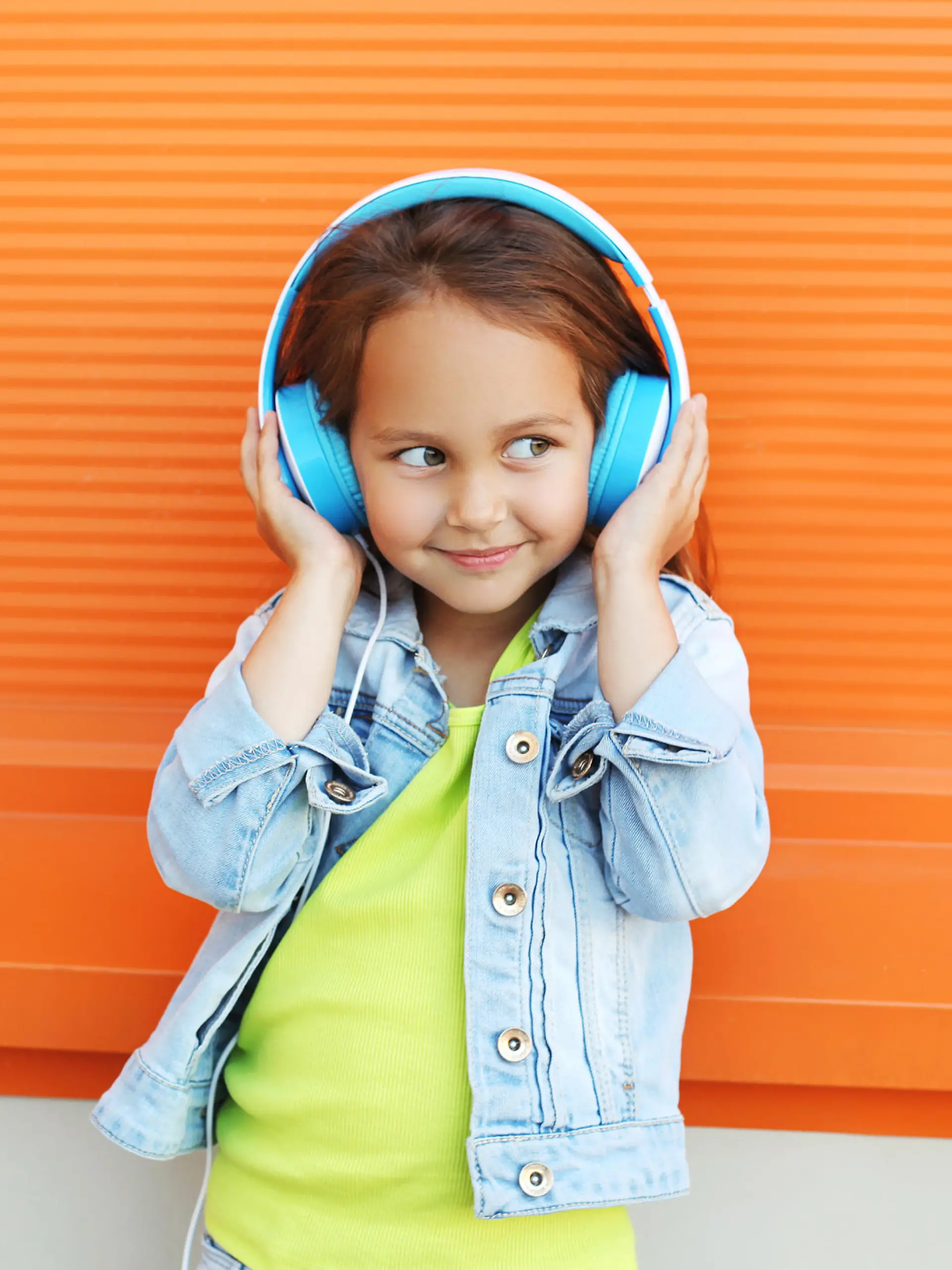Kinderkopfhörer: Kleines Mädchen hört Musik.