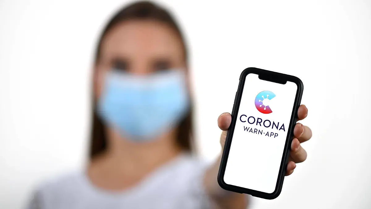 Frau mit Mundschutzmaske, zeigt Smartphone mit Corona Warn-APP, Corona-Krise, Baden-Württemberg, Deutschland, Europa *** Woman with face mask, showing Smartphone with Corona Warn APP, Corona crisis, Baden Württemberg, Germany, Europe Copyright: imageBROKER/MichaelxWeber iblimw05851155.jpg Bitte beachten Sie die gesetzlichen Bestimmungen des deutschen Urheberrechtes hinsichtlich der Namensnennung des Fotografen im direkten Umfeld der Veröffentlichung!
