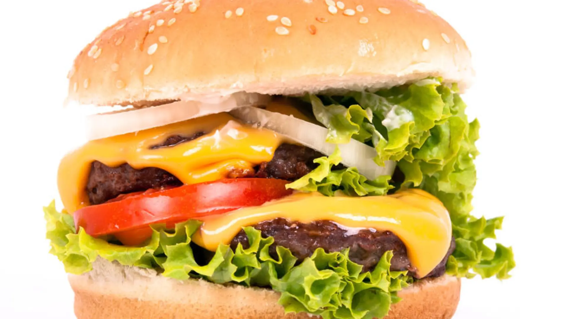 ein Cheeseburger mit Tomate, Salat und Zwiebeln vor weißem Hintergrund