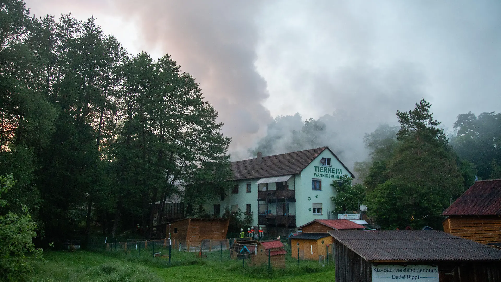 09.06.2021, Münnerstadt: Einsatzkräfte der Feuerwehr gehen an einem Gebäude des Tierheims entlang. Bei einem Brand in einem Tierheim in Unterfranken sind mehr als 100 Tiere ums Leben gekommen. Foto: Stefan Weber/Fuldamedia/dpa +++ dpa-Bildfunk +++
