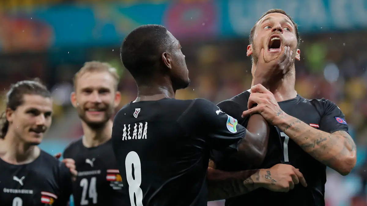 Austria's Marko Arnautovic, right, celebrates with Austria's David Alaba after scoring his side's third goal during the Euro 2020 soccer championship group C match between Austria and Northern Macedonia at the National Arena stadium in Bucharest, Romania, Sunday, June 13, 2021. (Robert Ghement/Pool via AP)