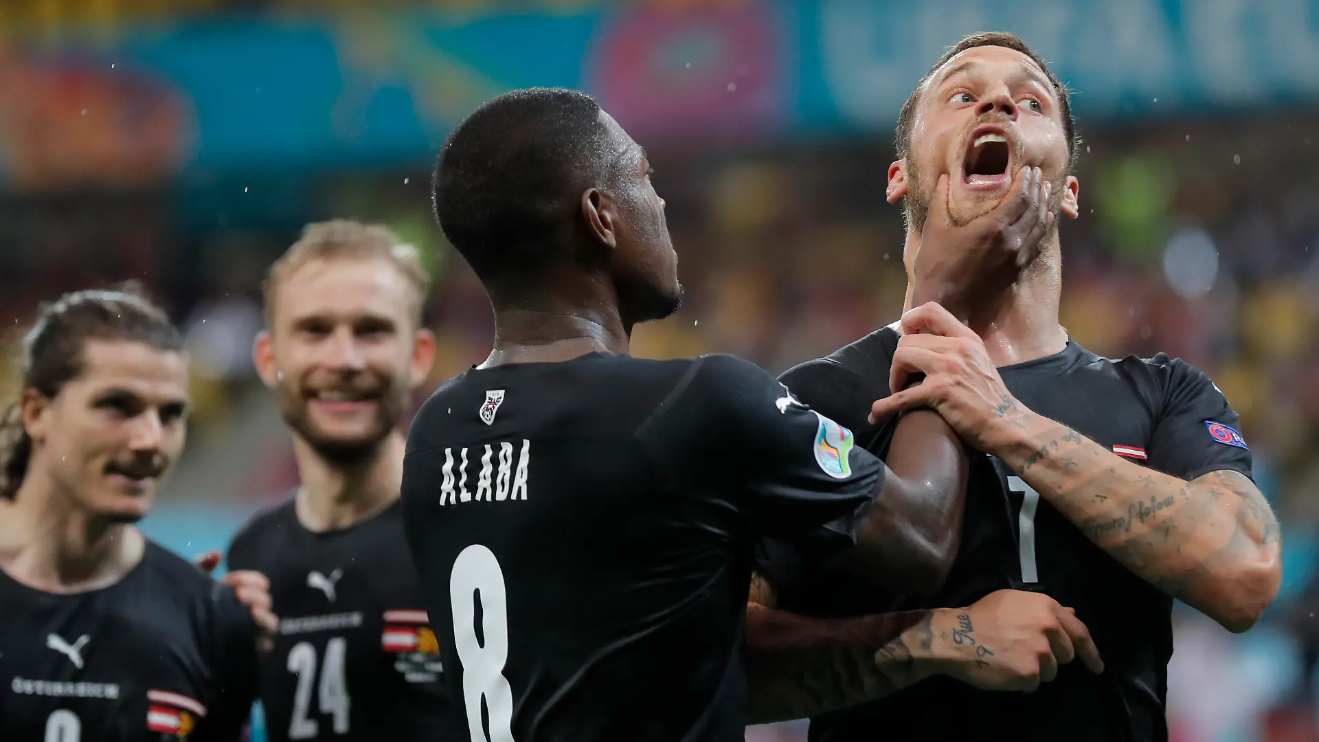 Austria's Marko Arnautovic, right, celebrates with Austria's David Alaba after scoring his side's third goal during the Euro 2020 soccer championship group C match between Austria and Northern Macedonia at the National Arena stadium in Bucharest, Romania, Sunday, June 13, 2021. (Robert Ghement/Pool via AP)