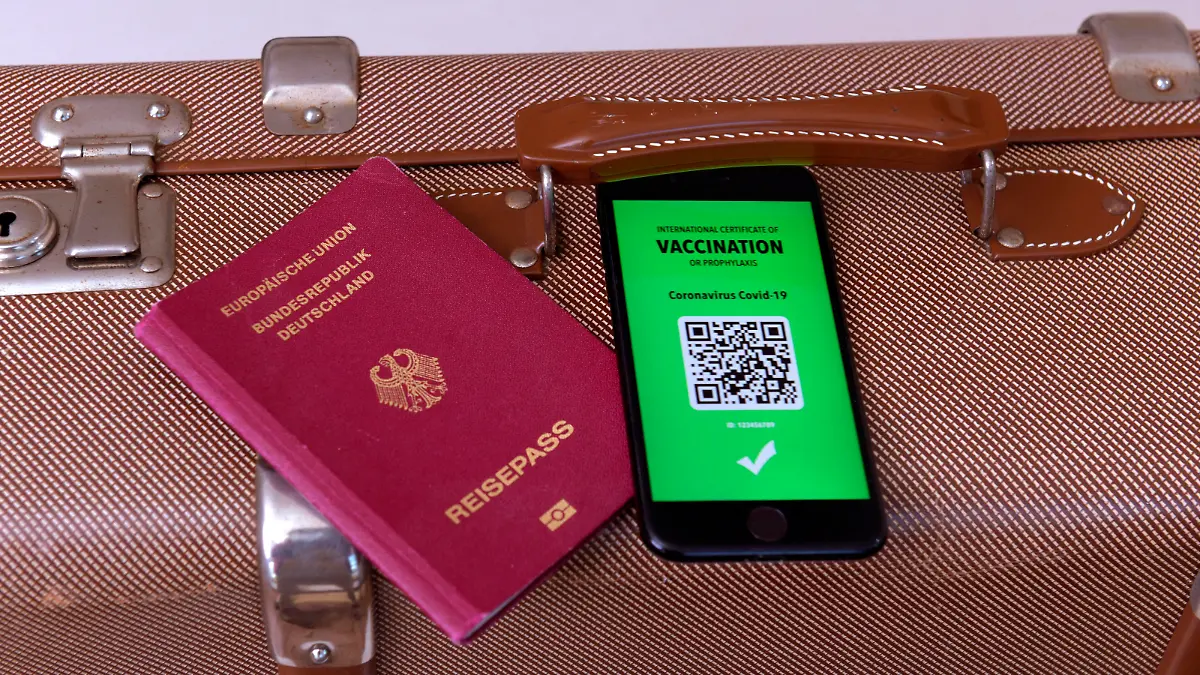 17.03.2021, Symbolbild, Impfung. Ein imaginärer Impfpass in digitaler Form auf dem Smartphone iPhone, bereitgelegt auf einem Reisekoffer mit einem Reisepass. Der digitale Impfpass würde wieder uneingeschränktes Reisen ermöglichen, 17.03.2021, Elektronischer Impfpass für Urlaubsreisen 17.03.2021, Elektronischer Impfpass für Urlaubsreisen *** 17 03 2021, Symbolic image, Vaccination An imaginary vaccination certificate in digital form on the smartphone iPhone, placed at the ready on a travel case with a passport The digital vaccination certificate would once again enable unrestricted travel, 17 03 2021, Electronic vaccination certificate for holiday travel 17 03 2021, Electronic vaccination certificate for holiday travel 