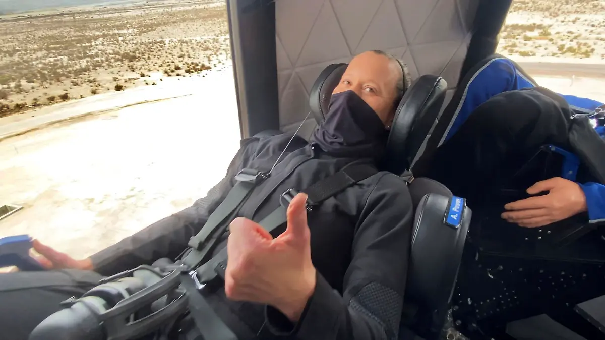 In this photo made available by Blue Origin, Audrey Powers gives a thumbs up inside the New Shepard rocket capsule during a crew rehearsal in West Texas on Wednesday, April 14, 2021. Two employees were strapped into the fueled rocketship for practice