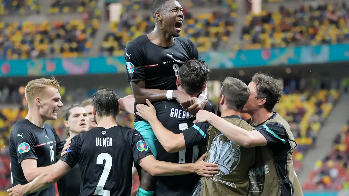 Austria's Michael Gregoritsch, center down, celebrates with teammates after scoring his side's second goal during the Euro 2020 soccer championship group C match between Austria and Northern Macedonia at the National Arena stadium in Bucharest, Romania, Sunday, June 13, 2021. (AP Photo/Vadim Ghirda, Pool)