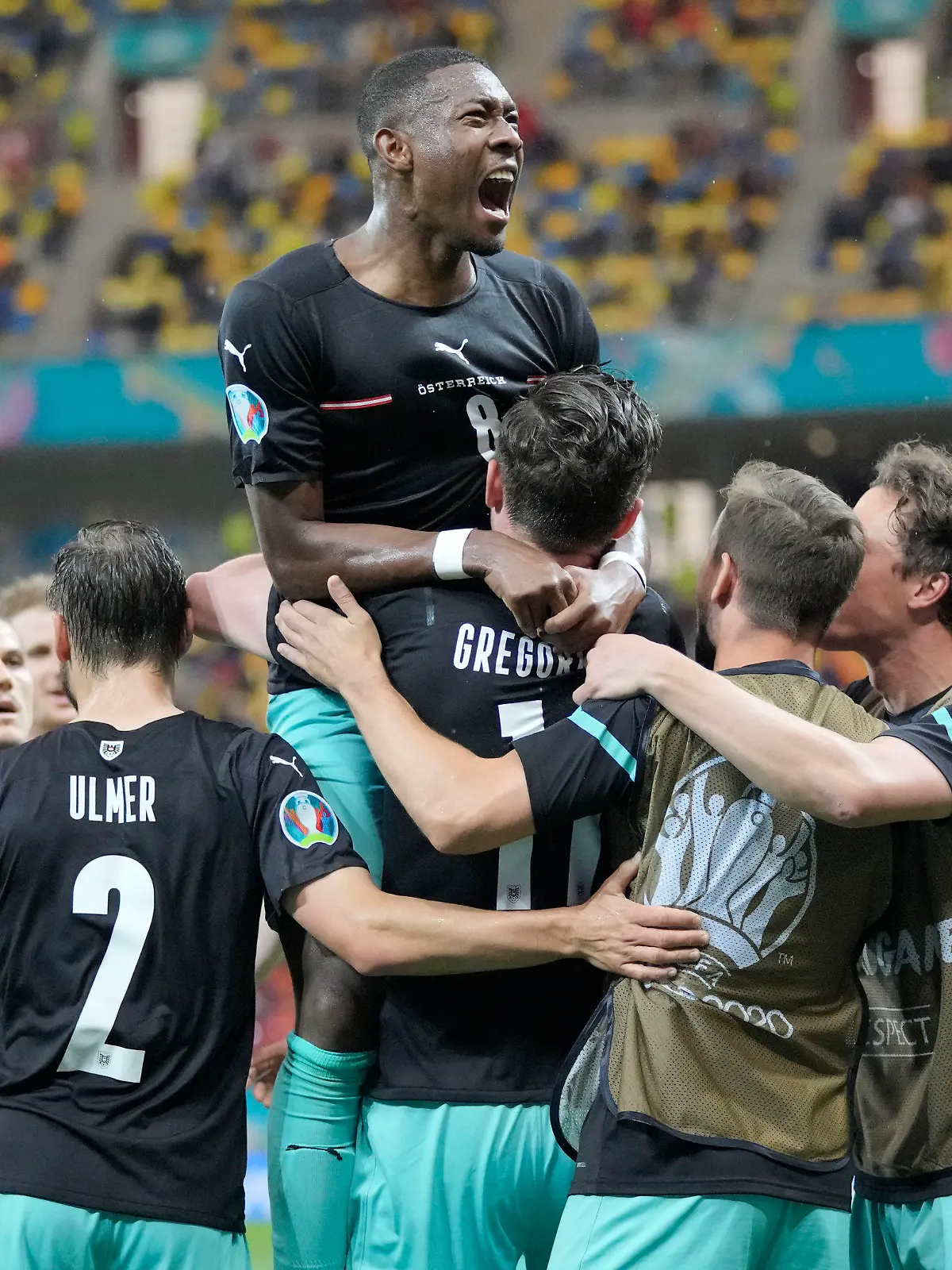 Austria's Michael Gregoritsch, center down, celebrates with teammates after scoring his side's second goal during the Euro 2020 soccer championship group C match between Austria and Northern Macedonia at the National Arena stadium in Bucharest, Romania, Sunday, June 13, 2021. (AP Photo/Vadim Ghirda, Pool)