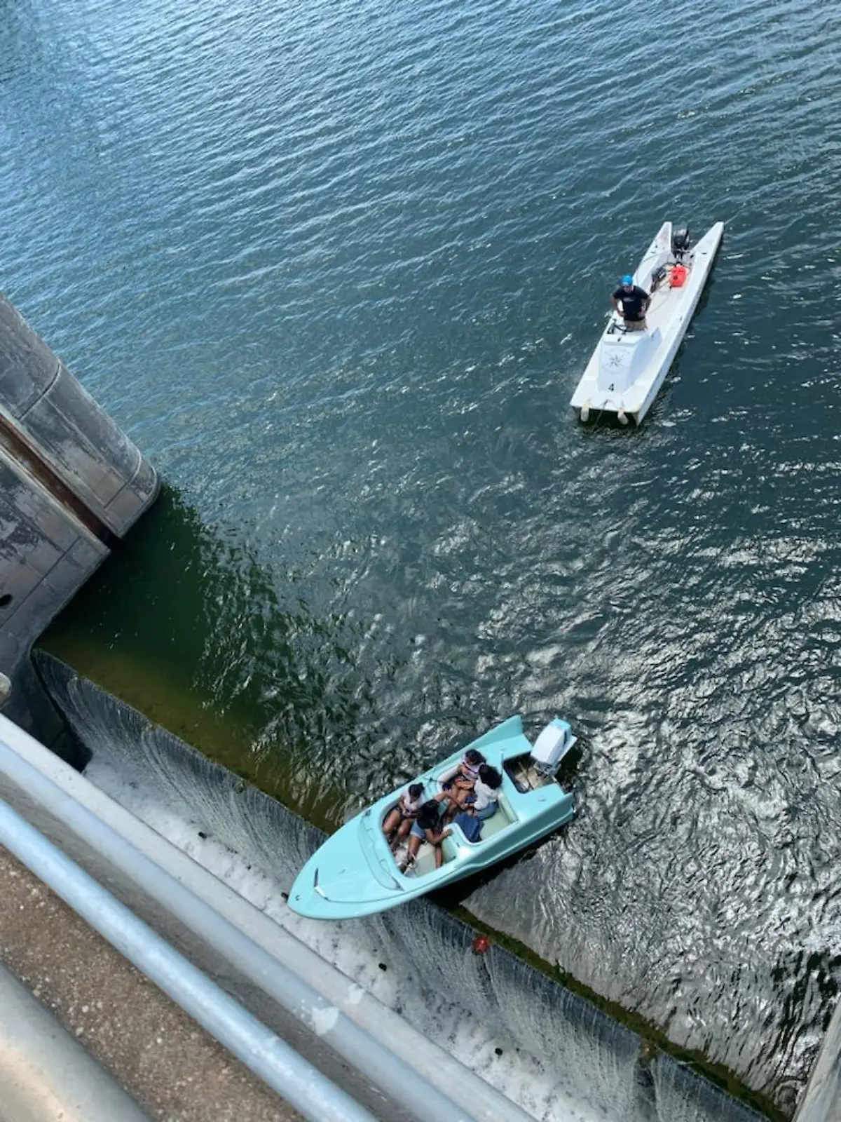 HANDOUT - 11.06.2021, USA, Austin: Ein Boot mit vier Insassen hängt am Longhorn-Damm über dem Abgrund.  Das Boot sei zu nah an eine der Schleusen herangefahren und habe sich aus eigener Kraft nicht aus der Notlage befreien können. Die Insassen konnten gerettet werden. (zu dpa "Nase über dem Abgrund: Boot hängt über Damm in den USA") Foto: Austin-Travis County Emergency Medical Services/dpa - ACHTUNG: Nur zur redaktionellen Verwendung im Zusammenhang mit der aktuellen Berichterstattung und nur mit vollständiger Nennung des vorstehenden Credits +++ dpa-Bildfunk +++