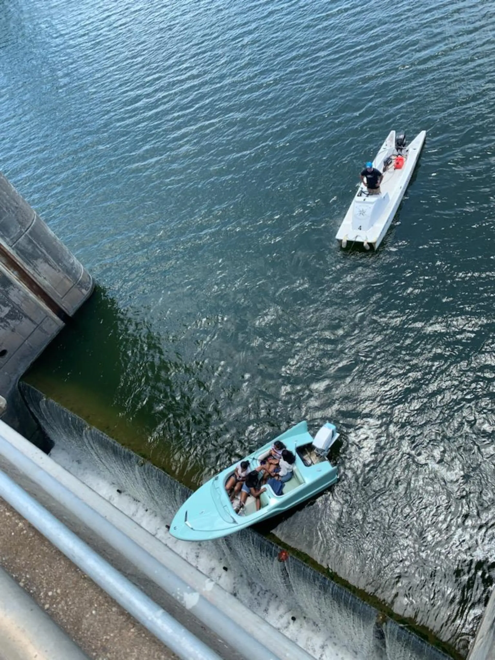 HANDOUT - 11.06.2021, USA, Austin: Ein Boot mit vier Insassen hängt am Longhorn-Damm über dem Abgrund.  Das Boot sei zu nah an eine der Schleusen herangefahren und habe sich aus eigener Kraft nicht aus der Notlage befreien können. Die Insassen konnten gerettet werden. (zu dpa "Nase über dem Abgrund: Boot hängt über Damm in den USA") Foto: Austin-Travis County Emergency Medical Services/dpa - ACHTUNG: Nur zur redaktionellen Verwendung im Zusammenhang mit der aktuellen Berichterstattung und nur mit vollständiger Nennung des vorstehenden Credits +++ dpa-Bildfunk +++