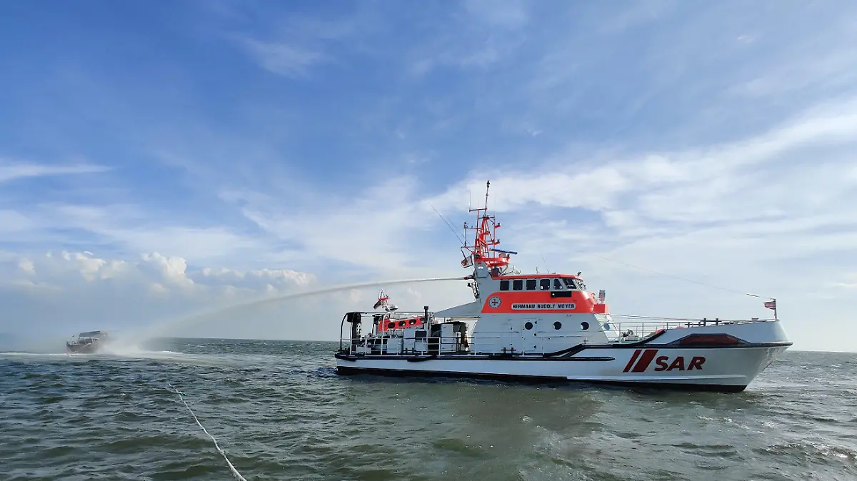 11.06.2021, Niedersachsen, Bremerhaven: Der Seenotrettungskreuzer Hermann Rudolf Meyer der Deutschen Gesellschaft zur Rettung Schiffbrüchiger (DGzRS) ist beim Löscheinsatz für ein brennendes Motorboot in der Wesermündung zu sehen. (zu dpa «Spektakuläre Rettung eines Motorbootfahrers aus Nordsee») Foto: -/DGzRS · Die Seenotretter/dpa +++ dpa-Bildfunk +++