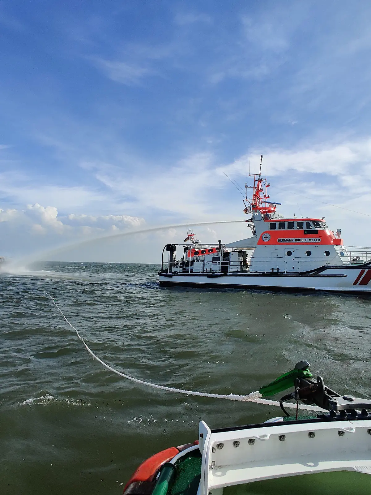 11.06.2021, Niedersachsen, Bremerhaven: Der Seenotrettungskreuzer Hermann Rudolf Meyer der Deutschen Gesellschaft zur Rettung Schiffbrüchiger (DGzRS) ist beim Löscheinsatz für ein brennendes Motorboot in der Wesermündung zu sehen. (zu dpa «Spektakuläre Rettung eines Motorbootfahrers aus Nordsee») Foto: -/DGzRS · Die Seenotretter/dpa +++ dpa-Bildfunk +++