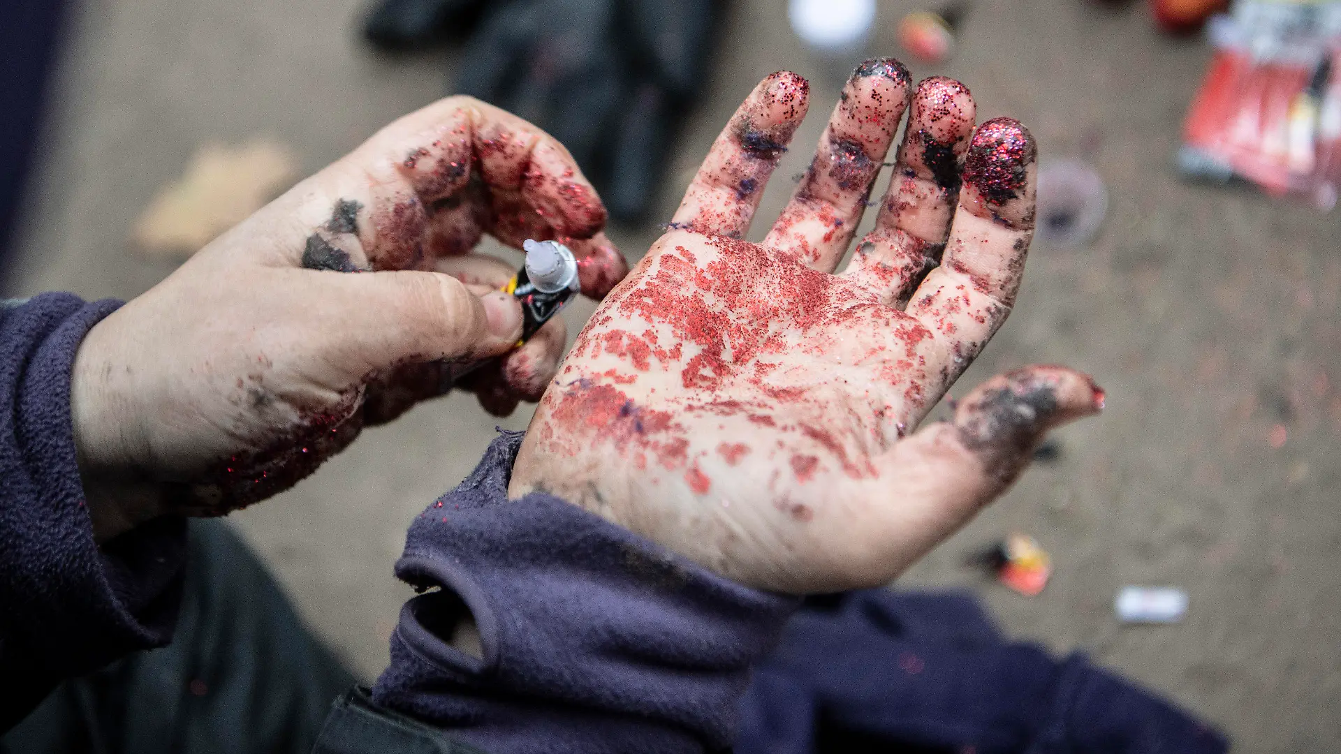 ARCHIV - 29.11.2020, Hessen, Dannenrod: Mit Sekundenkleber und Glitter verschmiert ein Aktivist seine Hände, um für den Fall einer Festnahme eine Fingerabdrucknahme durch die Polizei zu erschweren. (Zu dpa «Kostenbescheide nach Großeinsatz im Dannenröder Forst versandt») Foto: Boris Roessler/dpa +++ dpa-Bildfunk +++
