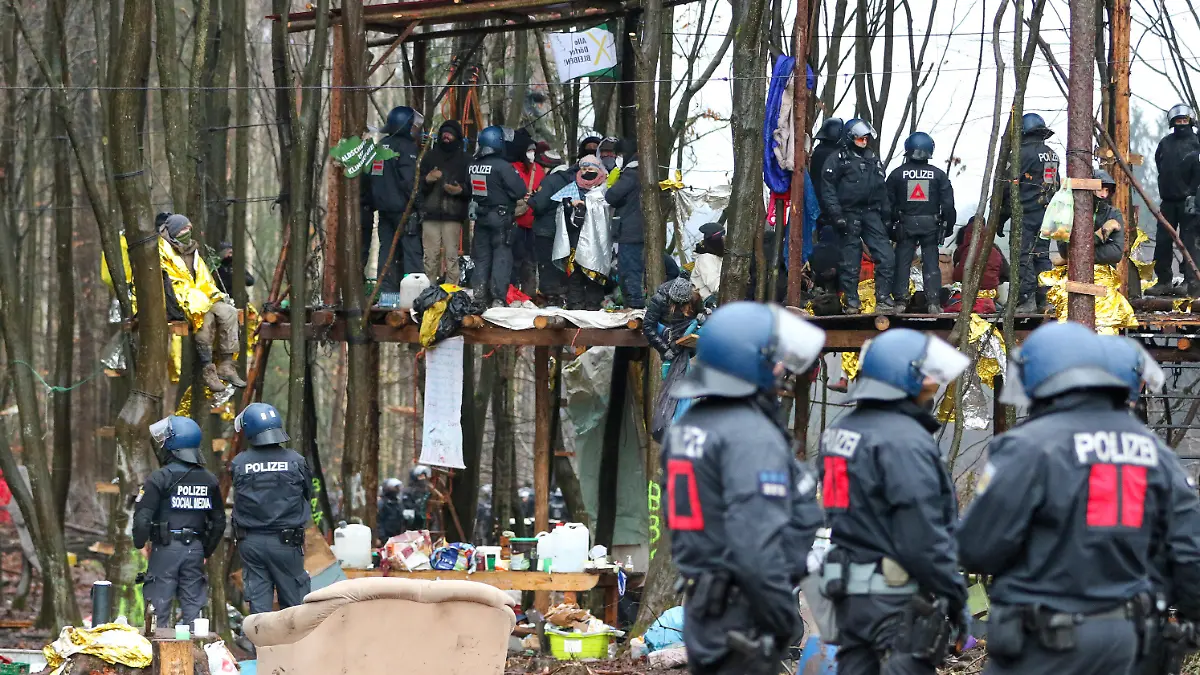 ARCHIV - 07.12.2020, Hessen, Dannenrod: Polizisten und Umweltaktivisten stehen auf einer Plattform in einem Camp im Dannneröder Forst (zu dpa «Räumungen im Dannenröder Forst kosteten zweistelligen Millionenbetrag»). Foto: Nadine Weigel/dpa +++ dpa-Bildfunk +++