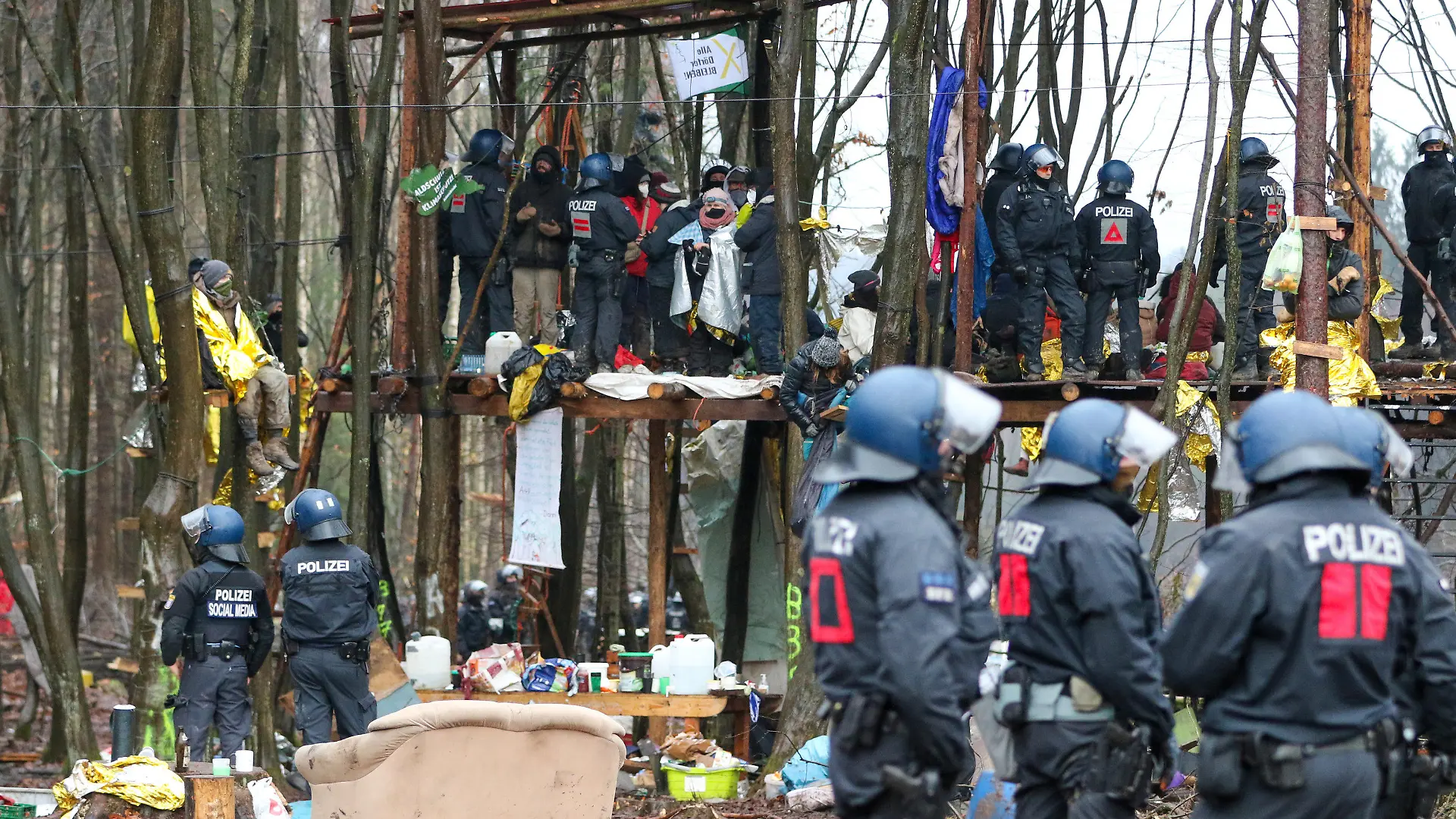 ARCHIV - 07.12.2020, Hessen, Dannenrod: Polizisten und Umweltaktivisten stehen auf einer Plattform in einem Camp im Dannneröder Forst (zu dpa «Räumungen im Dannenröder Forst kosteten zweistelligen Millionenbetrag»). Foto: Nadine Weigel/dpa +++ dpa-Bildfunk +++