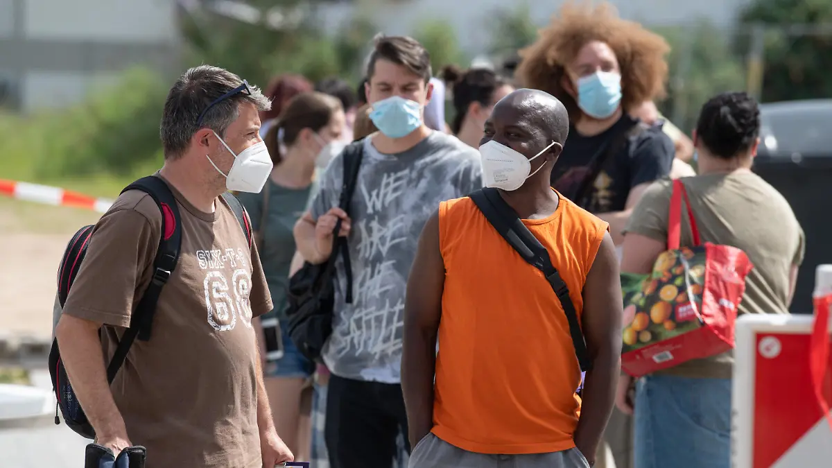 12.06.2021, Hessen, Babenhausen: Impfwillige warten im Freien auf Einlass in eine Arztpraxis im hessischen Babenhausen. Ein Hausarzt hatte hier 1000 Impfdosen Impfdosen erhalten und zu einem ·offenen Impftag· für Corona-Schutzimpfungen aufgerufen. Ein Teil der Impfwilligen hatte auf dem Bürgersteig vor der Praxis übernachtet. Foto: Boris Roessler/dpa +++ dpa-Bildfunk +++