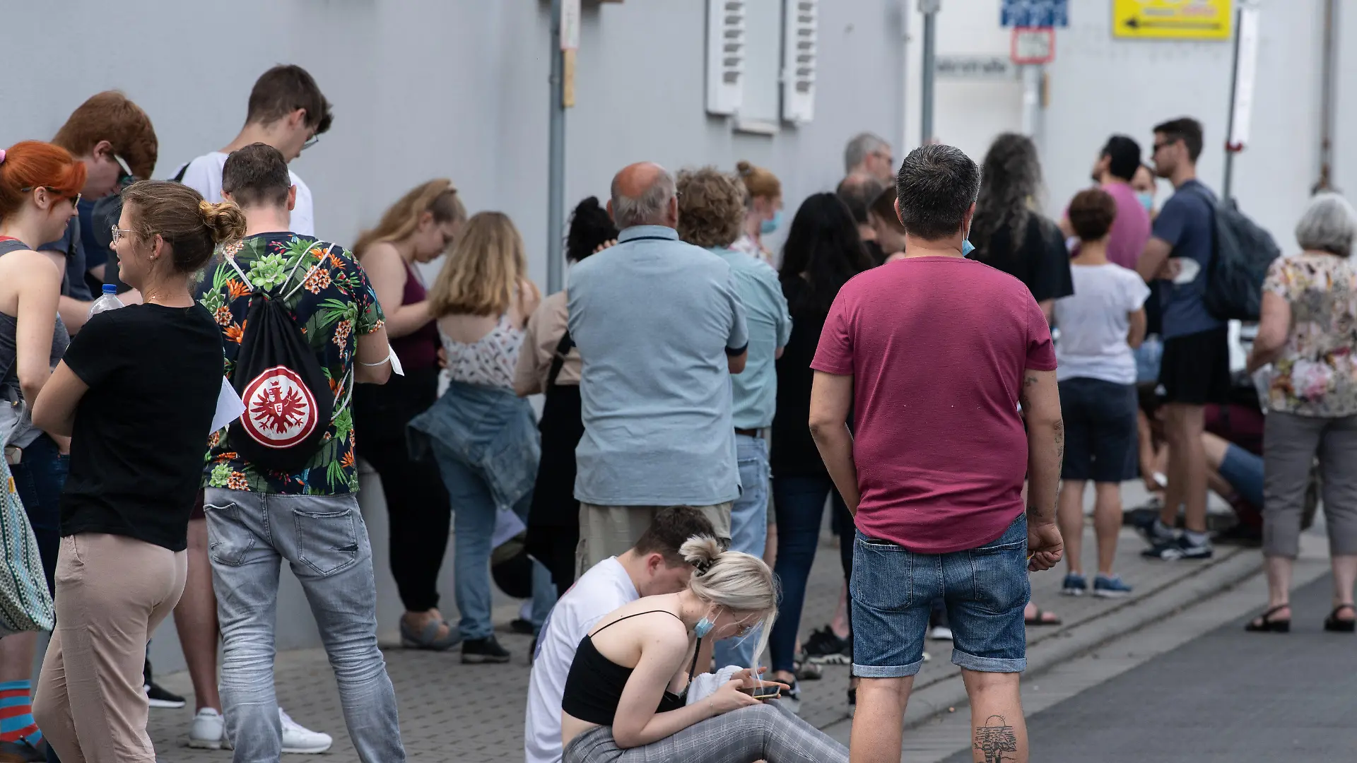 12.06.2021, Hessen, Babenhausen: Insgesamt mehr als 1500 Menschen warten bei sommerlichen Temperaturen im Freien auf Einlass in eine Arztpraxis im hessischen Babenhausen. Ein Hausarzt hatte hier 1000 Impfdosen Impfdosen erhalten und zu einem ·offenen Impftag· für Corona-Schutzimpfungen aufgerufen. Ein Teil der Impfwilligen hatte auf dem Bürgersteig vor der Praxis übernachtet. Foto: Boris Roessler/dpa - ACHTUNG: Verwendung nur im vollen Format +++ dpa-Bildfunk +++