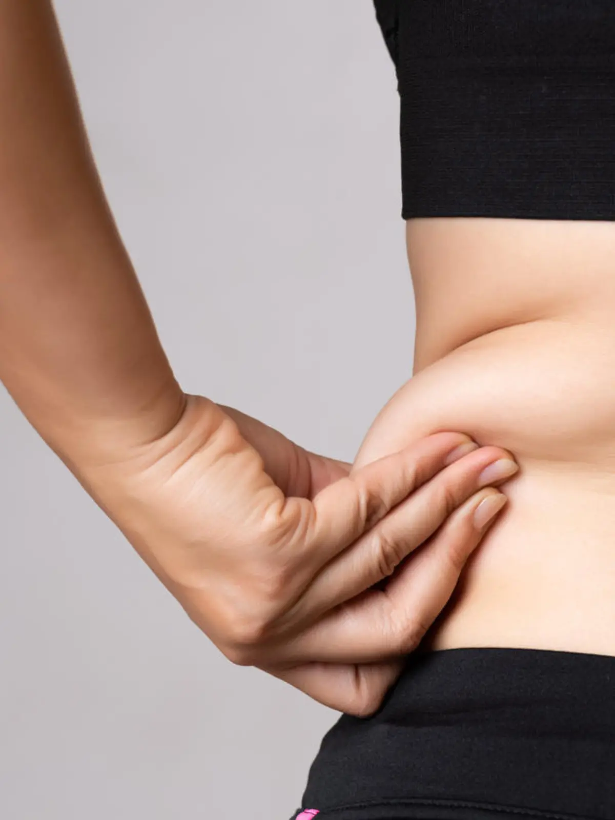 Fat woman hand holding excessive belly fat. Healthcare and woman diet lifestyle concept to reduce belly and shape up healthy stomach muscle.