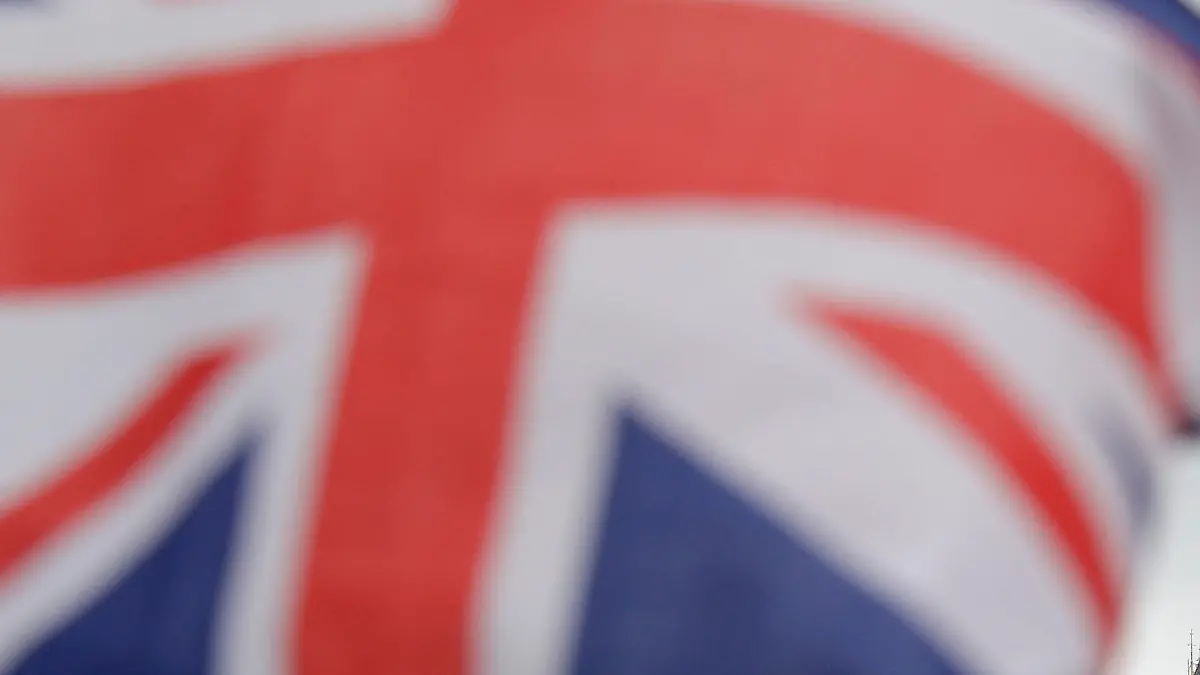 Britische Fähnchen an einem Touristen-Geschäft wehen am 29.03.2017 vor den Houses of Parliament in London mit dem Elizabeth Tower (r), in dem die Glocke Big Ben hängt. Großbritannien hat als erster Mitgliedsstaat in der Geschichte der Europäischen Union seinen Austritt verkündet. Foto: Matt Dunham/AP/dpa +++(c) dpa - Bildfunk+++