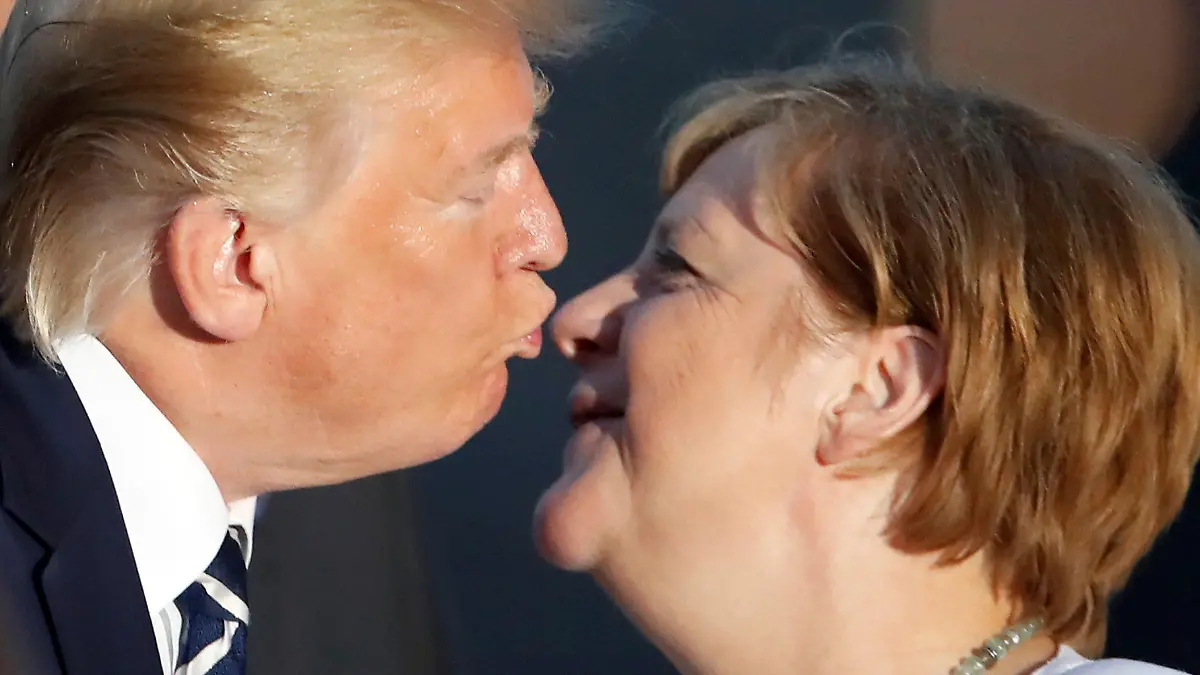 25.08.2019, Frankreich, Biarritz: Donald Trump, Präsident der USA, küsst Bundeskanzlerin Angela Merkel (CDU), zur Begrüßung beim gemeinsamen Familienfoto im Rahmen des G7-Gipfels. Der G7-Gipfel findet vom 24.-26. August in Biarritz statt. (Wiederholung mit verändertem Bildausschnitt) Foto: Christian Hartmann/POOL Reuters/AP/dpa +++ dpa-Bildfunk +++