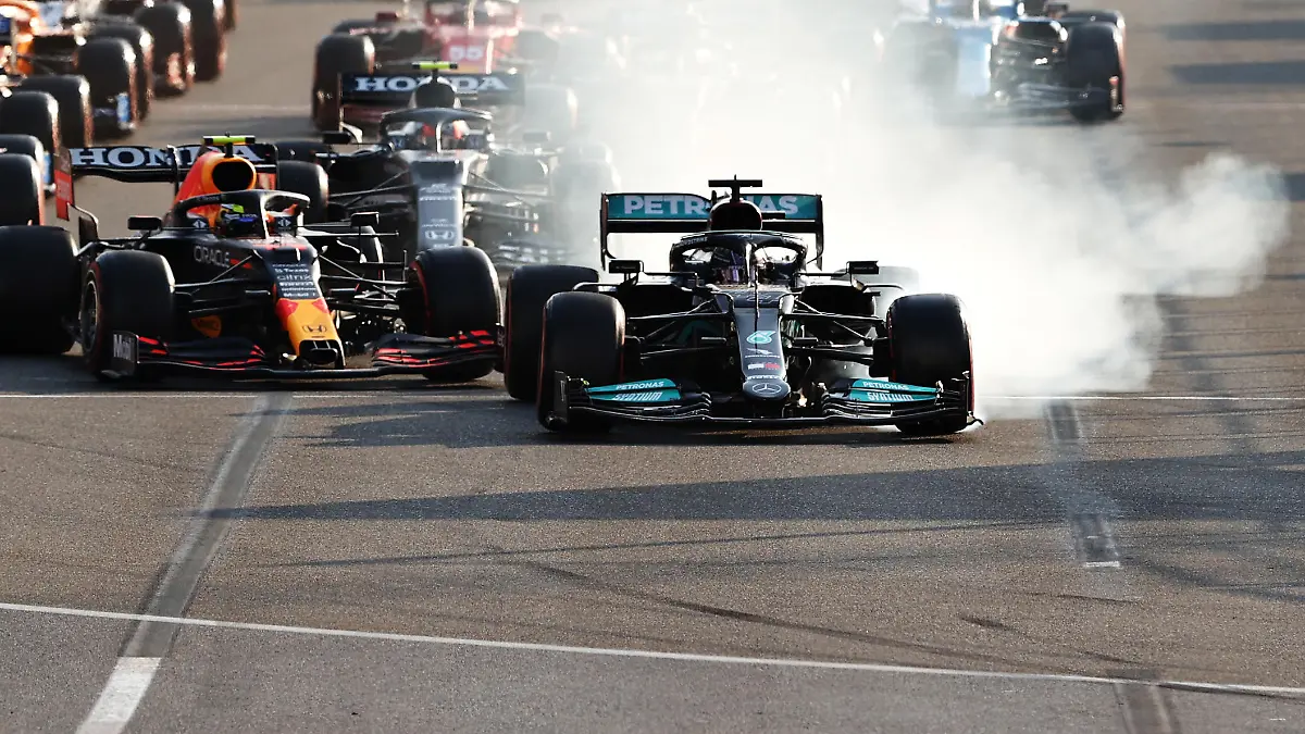 BAKU, AZERBAIJAN - JUNE 06: Lewis Hamilton of Great Britain driving the (44) Mercedes AMG Petronas F1 Team Mercedes W12 locks up under pressure from Sergio Perez of Mexico driving the (11) Red Bull Racing RB16B Honda into the first corner after the restart following a red flag period during the F1 Grand Prix of Azerbaijan at Baku City Circuit on June 06, 2021 in Baku, Azerbaijan. (Photo by Clive Rose/Getty Images)