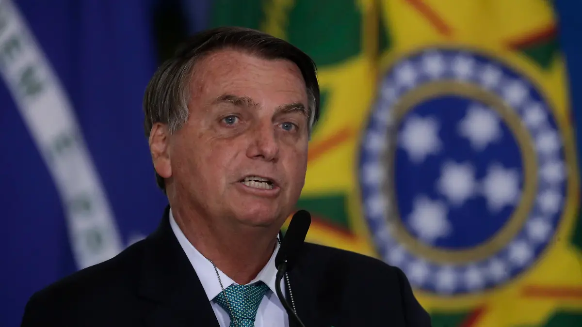 Brazil's President Jair Bolsonaro confirms his country to host the 2021 Copa America soccer tournament, during a ceremony of the state bank sponsoring Brazilian athletics, at the Planalto presidential palace, in Brasilia, Brazil, Tuesday, June 1, 2021. (AP Photo/Eraldo Peres)