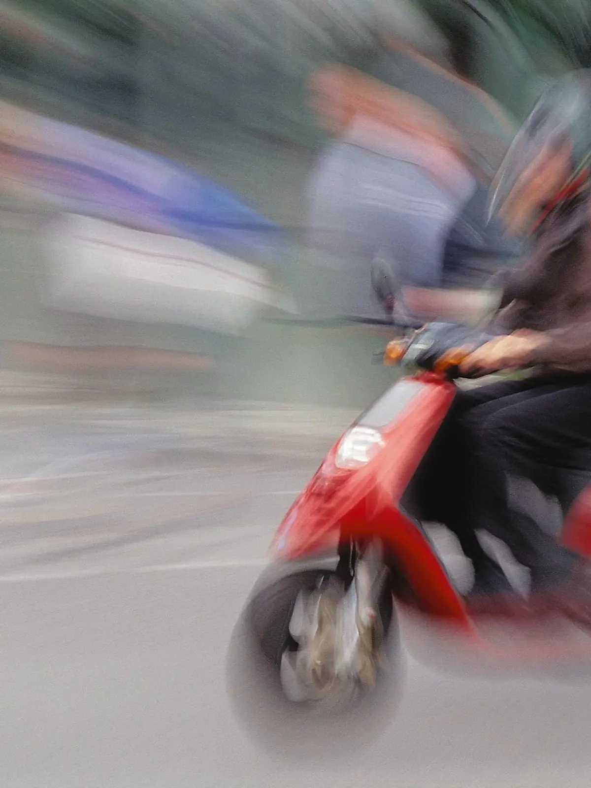 Verschwommene Aufnahme eines fahrenden Rollers.
