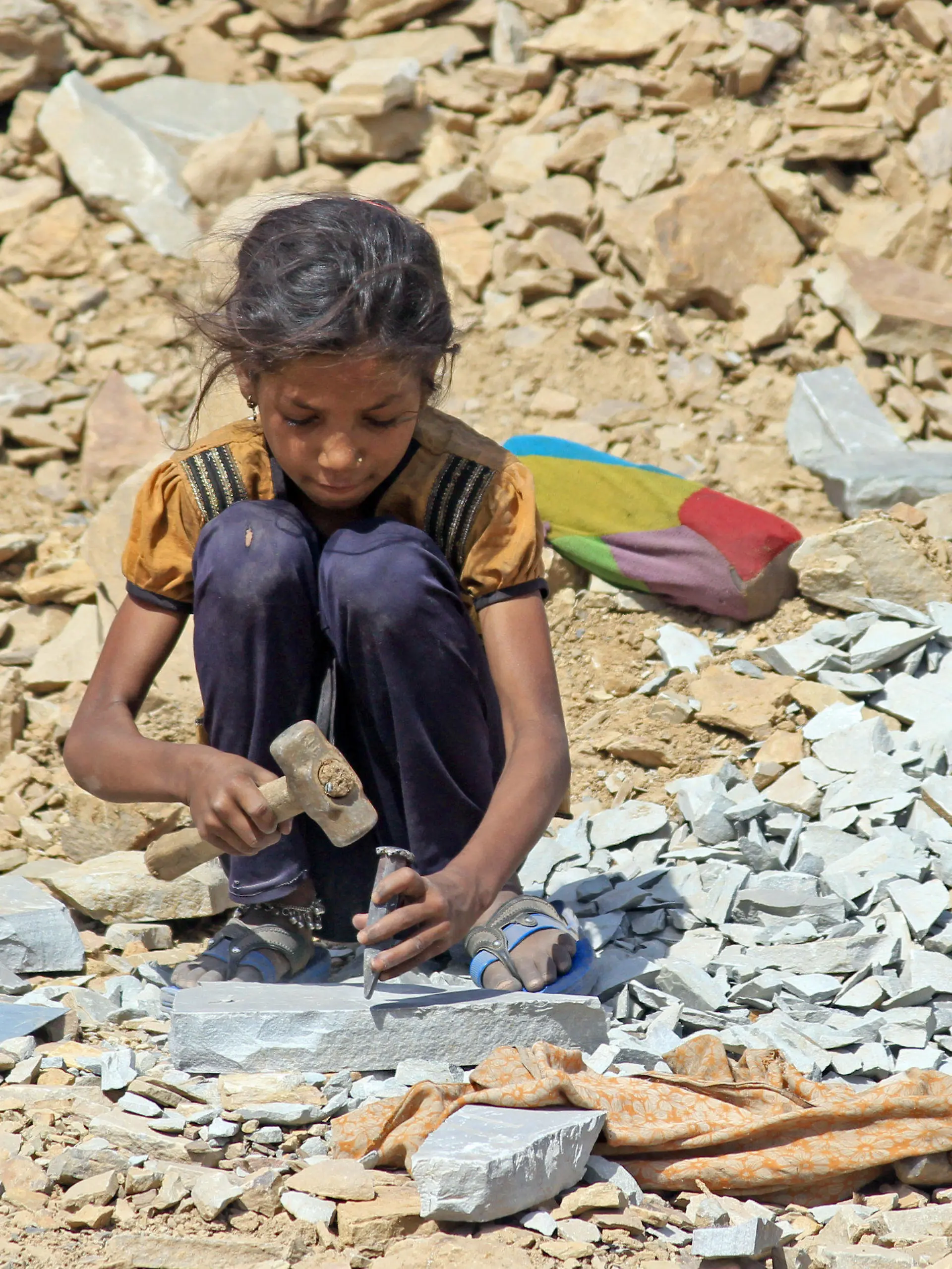 Die etwa 8-jährige Sunita sitzt am 16.05.2013 in Kota, in der indischen Provinz Rajasthan, in einem Steinbruch und arbeitet mit Hammer und Meißel. Tausende Kinder hauen in Steinbrüchen in Indien Pflastersteine für den europäischen Markt.    Foto: Doreen Fiedler/dpa   (zu dpa "Kleine Hände hauen in Indien Pflastersteine für Europa" vom 11.06.2013) +++(c) dpa - Bildfunk+++
