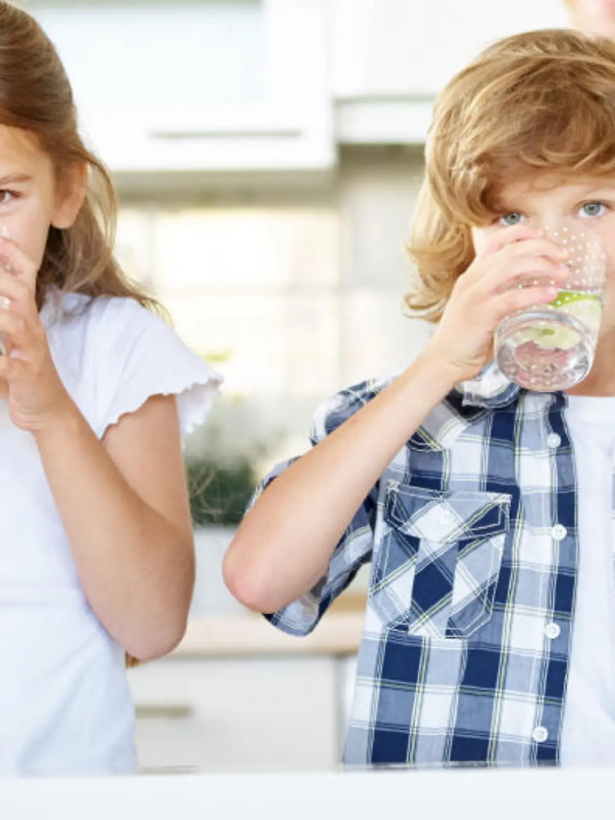 Kinder trinken Wasser aus Gläsern