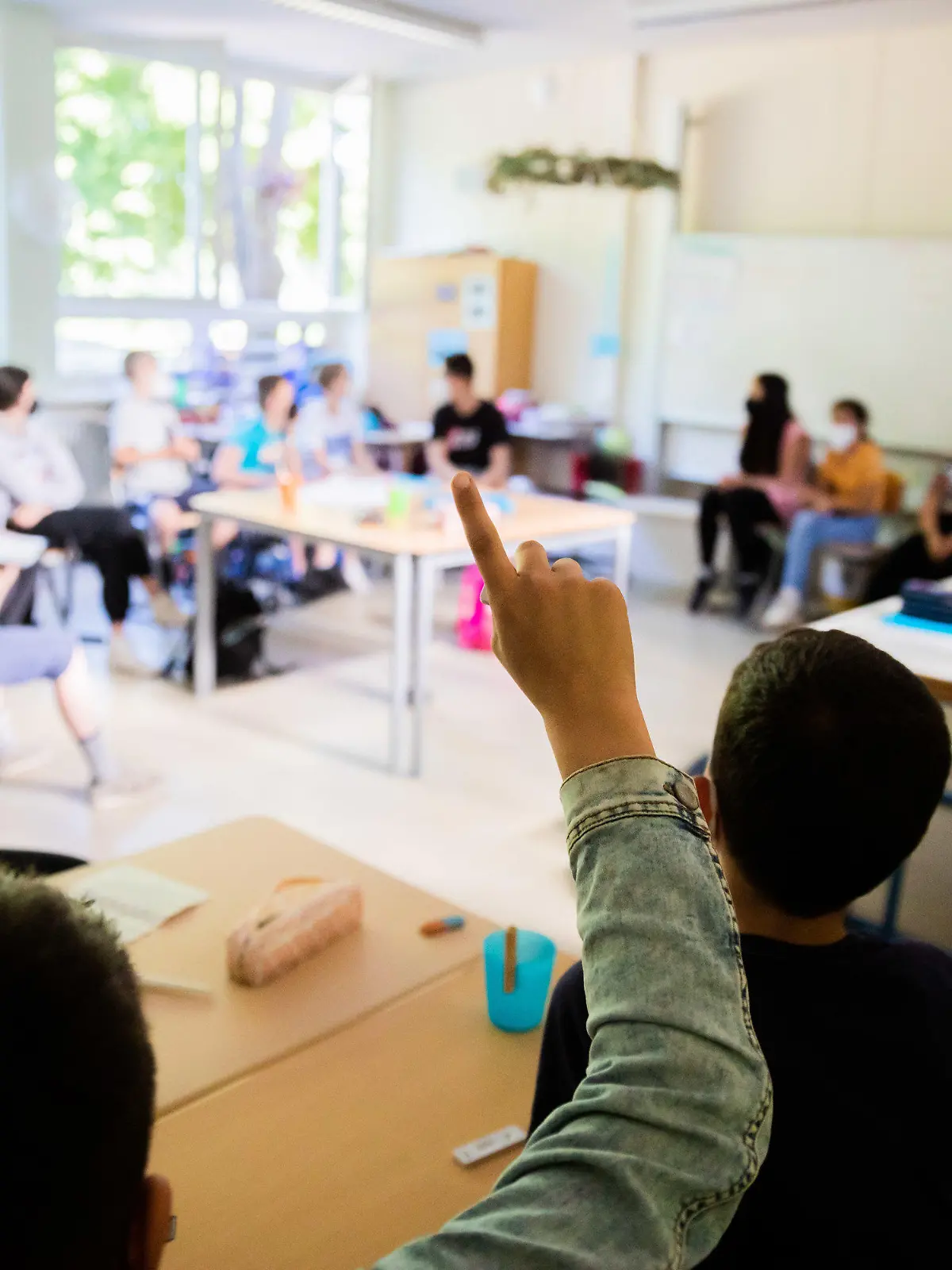 09.06.2021, Berlin: Ein Schüler meldet sich in einer gemischten Klasse der Stufen 4-6 an der Fritz-Karsen-Schule im Berliner Ortsteil Britz. Für die letzten zwei Wochen vor den Sommerferien gibt es in der Hauptstadt noch einmal Präsenzunterricht mit allen Schülerinnen und Schülern. Foto: Christoph Soeder/dpa +++ dpa-Bildfunk +++