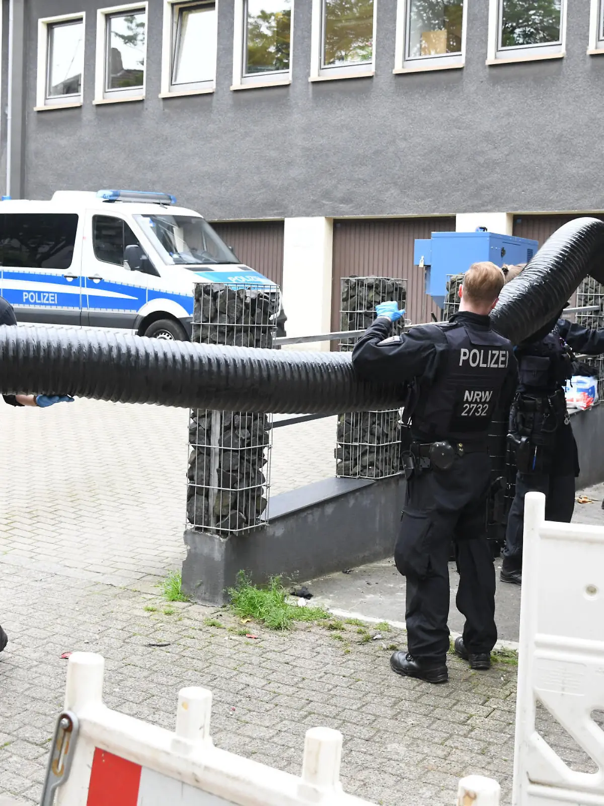 insatzkräfte stehen bei einem großangelegten Einsatz gegen die Rauschgiftkriminalität vor einem Bürogebäude in Essen.
