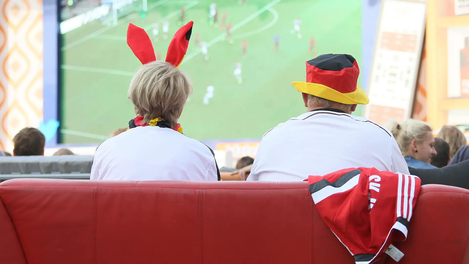 Fußballfans sitzen am 16.06.2014 im Stadion "Alte Försterei" des FC Union in Berlin beim WM-Spiel Deutschland gegen Portugal auf ihren mitgebrachten Sofas. Mehrere hundert Sofas waren zuvor von Fans in Stadion gebracht worden, um ein Public Viewing mit Wohnzimmeratmosphäre zu schaffen. Foto: Stephanie Pilick/dpa +++(c) dpa - Bildfunk+++