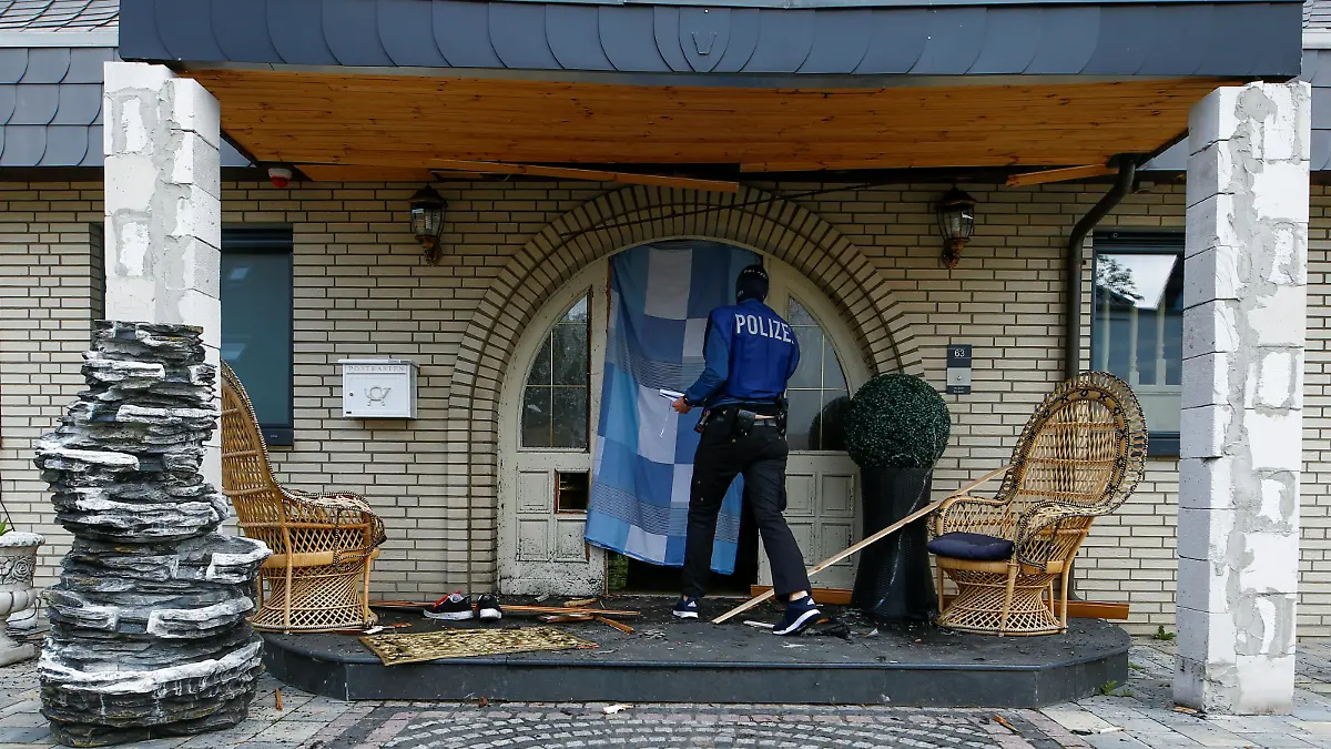A German police officer stands in front of a door to a villa that was opened with explosives by a SWAT team during a raid in the clan milieu in Leverkusen, Germany, June 8, 2021. REUTERS/Thilo Schmuelgen