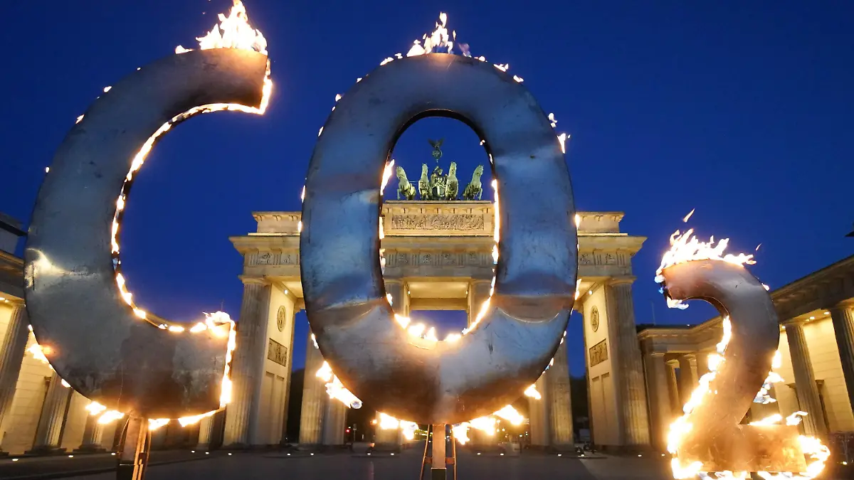 dpatopbilder - 06.05.2021, Berlin: Bei einer Greenpeace-Aktion steht ein CO-2 Schriftzug vor dem Brandenburger Tor, aus dem Flammen schlagen. Mit der Aktion fordern Aktivisten der Umweltschutz-Organisation Greenpeace die Bundesregierung auf, den CO-2 Ausstoß in Deutschland weiter zu reduzieren und auf die Einhaltung der Ziele des Weltklimagipfels von Paris zu achten. Foto: Jörg Carstensen/dpa +++ dpa-Bildfunk +++
