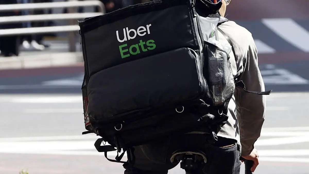 ARCHIV - 02.04.2020, Japan, Tokio: Ein Mitarbeiter des Essenslieferdienstes Uber Eats radelt mit einer Lieferung durch die Stadt. (zu dpa "Uber startet Essenlieferdienst Eats in Berlin") Foto: kyodo/dpa +++ dpa-Bildfunk +++