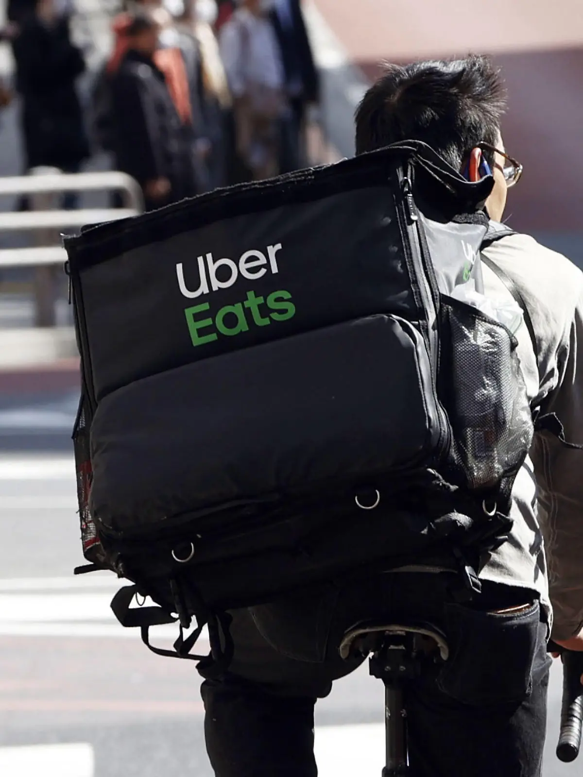 ARCHIV - 02.04.2020, Japan, Tokio: Ein Mitarbeiter des Essenslieferdienstes Uber Eats radelt mit einer Lieferung durch die Stadt. (zu dpa "Uber startet Essenlieferdienst Eats in Berlin") Foto: kyodo/dpa +++ dpa-Bildfunk +++