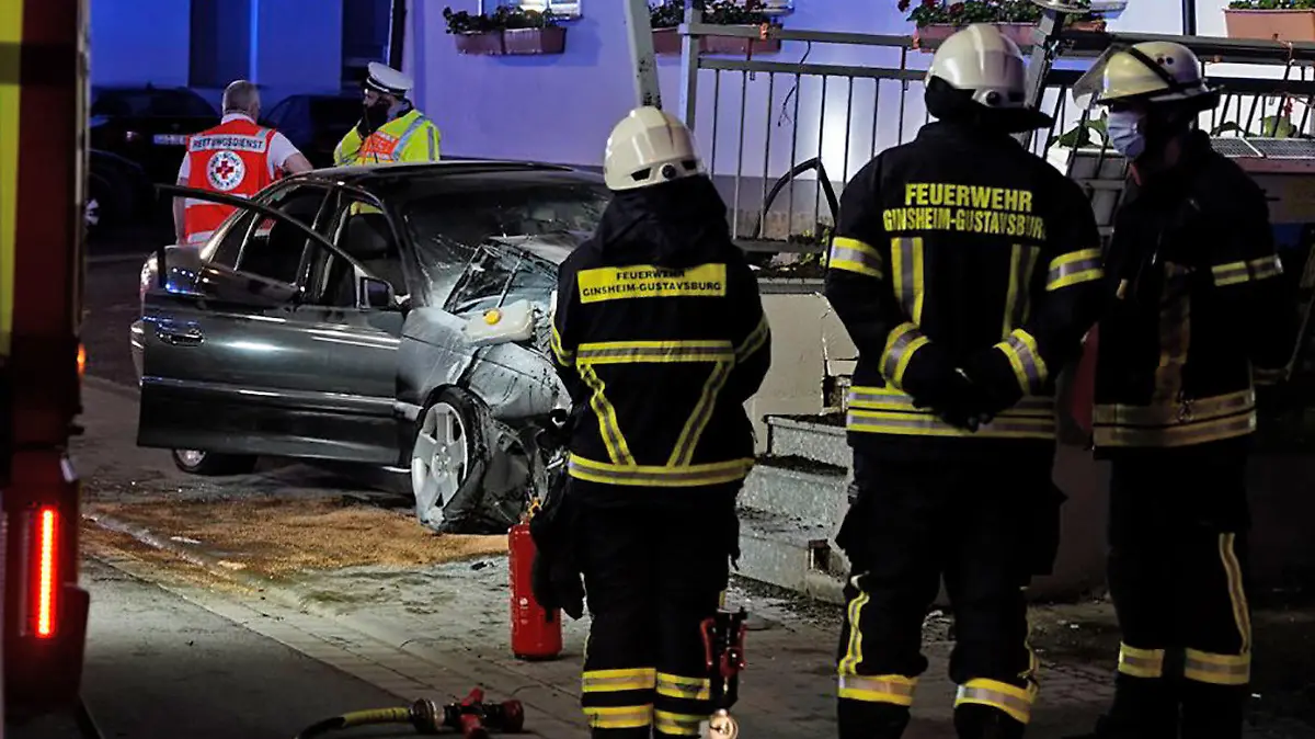 08.06.2021, Hessen, Ginsheim-Gustavsburg: Rettungskräfte und Feuerwehrleute arbeiten an einer Unfallstelle, an der ein 22 Jahre alter Autofahrer ist in der Nacht mit seinem Wagen in eine Hauswand gefahren und gestorben war. (zu dpa "Auto kracht nahezu ungebremst in Hauswand - 22-Jähriger stirbt") Foto: Felix Hirth/5Vision/dpa +++ dpa-Bildfunk +++
