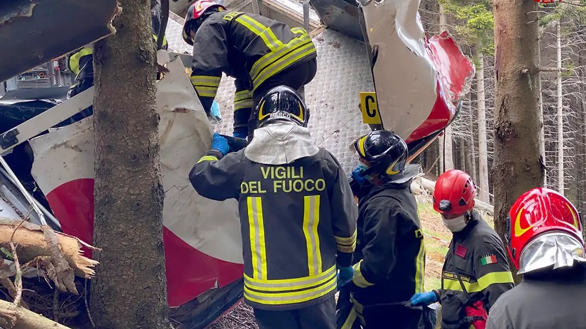 HANDOUT - 24.05.2021, Italien, Stresa: Retter arbeiten am Wrack einer abgestürzten Gondel, die in einem Waldstück liegt. Beim Absturz einer Gondel einer Seilbahn am norditalienischen Lago Maggiore haben mindestens 14 Menschen ihr Leben verloren. Foto: Uncredited/Vigili del Fuoco Firefighters/dpa - ACHTUNG: Nur zur redaktionellen Verwendung im Zusammenhang mit der aktuellen Berichterstattung und nur mit vollständiger Nennung des vorstehenden Credits. Verwendung nur bis zum 06.06.2021. +++ dpa-Bildfunk +++