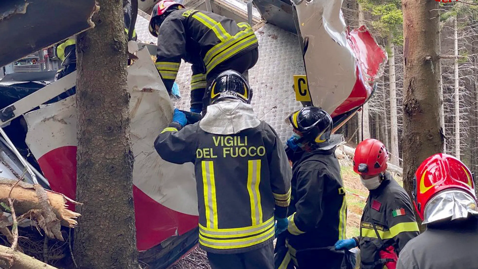 HANDOUT - 24.05.2021, Italien, Stresa: Retter arbeiten am Wrack einer abgestürzten Gondel, die in einem Waldstück liegt. Beim Absturz einer Gondel einer Seilbahn am norditalienischen Lago Maggiore haben mindestens 14 Menschen ihr Leben verloren. Foto: Uncredited/Vigili del Fuoco Firefighters/dpa - ACHTUNG: Nur zur redaktionellen Verwendung im Zusammenhang mit der aktuellen Berichterstattung und nur mit vollständiger Nennung des vorstehenden Credits. Verwendung nur bis zum 06.06.2021. +++ dpa-Bildfunk +++